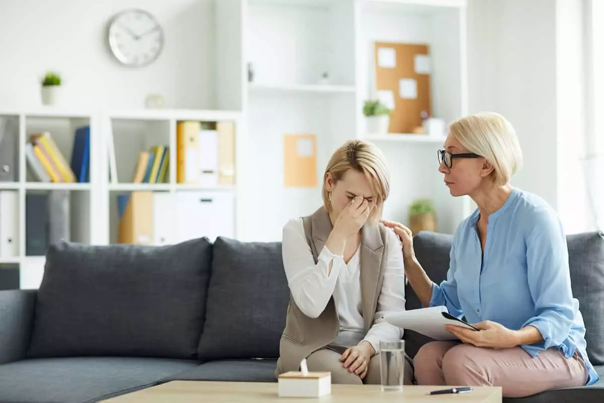 Woman being comforted by therapist